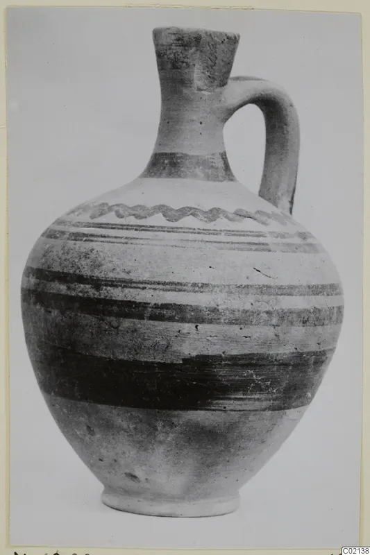 Pottery White Painted VII, a jug with a single handle and dark painted bands on a pale body