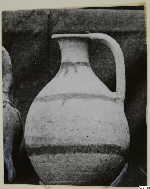 Pottery White Painted VII, a jug with a single handle and dark painted bands, photographed against a dark backdrop