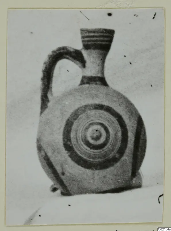 White Painted I jug with concentric circles on its body, photographed on a card mount