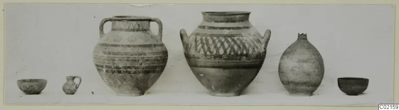 Six pottery vessels set in a row, including two large two-handled jars with painted bands and lattice decoration.