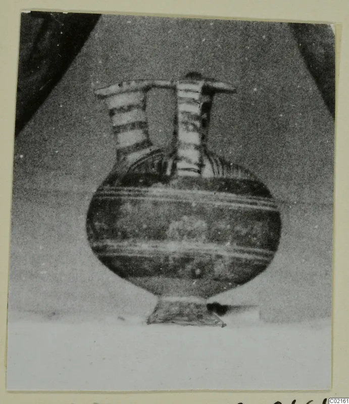 White Painted I jug from Marion, with two tall necks joined by a bar across the top and a rounded body
