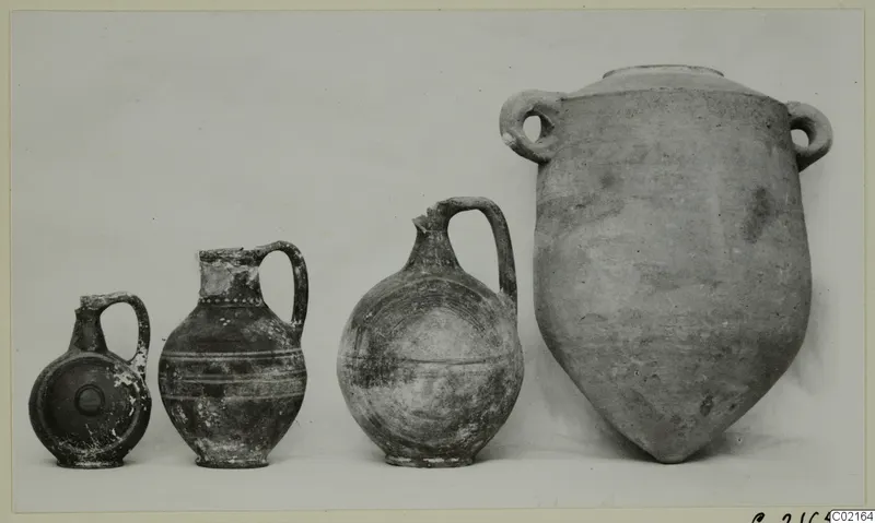 Four pottery vessels from Marion, Tomb 81 A, arranged in a row by size, from a small juglet to a large two-handled jar.