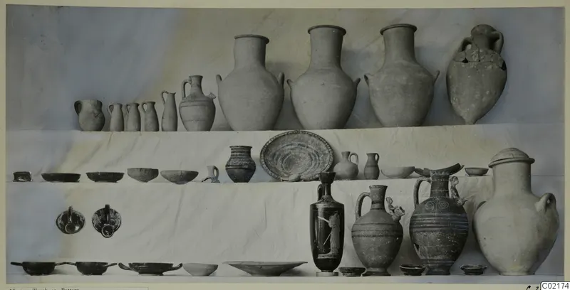 Pottery vessels from Tomb 41 at Marion, jars, jugs, bowls and plates arranged in tiers on white cloth