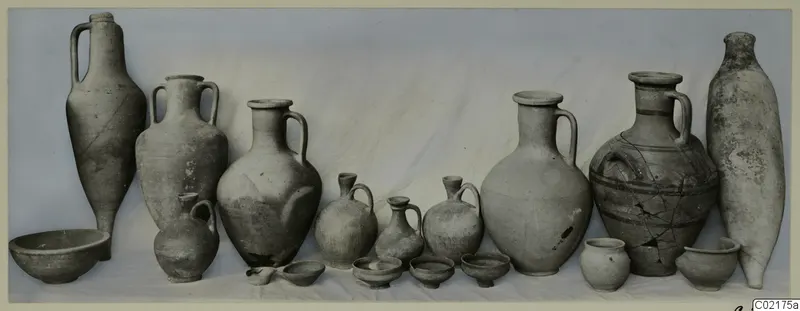 Pottery vessels from Marion, Tomb 53, arranged in a row against a draped cloth