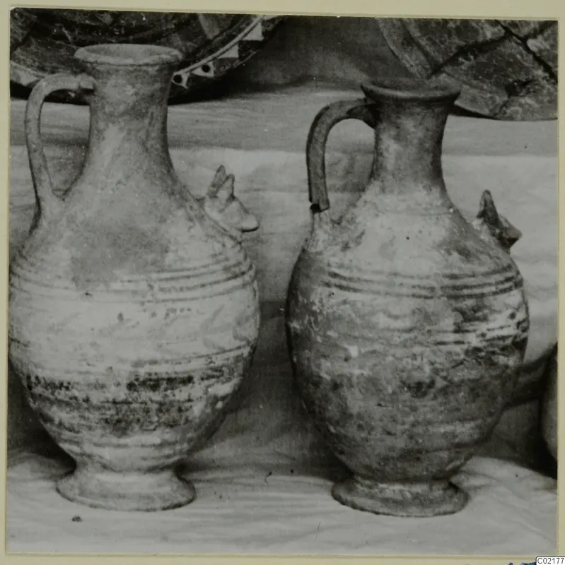 Two pottery jugs with banded bodies and ring feet, standing side by side.