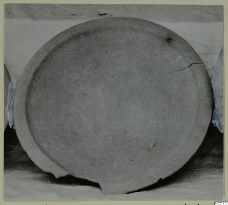 Plain White VI pottery vessel, a shallow circular dish seen from above, with a crack and chipped rim