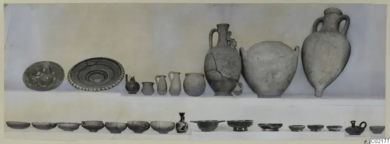 Pottery vessels from Marion Tomb 46: plates, jugs, jars and bowls laid out in two rows.