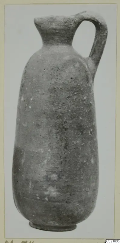 Pottery Red Slip I_III - V_VII jug with a narrow neck and single loop handle, shown upright