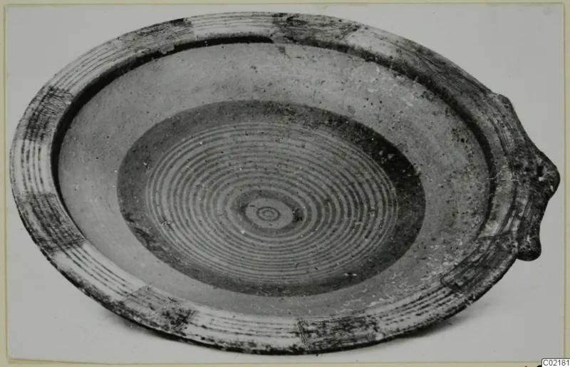 Shallow bowl with concentric painted rings in the centre and a lug on the rim, from Marion