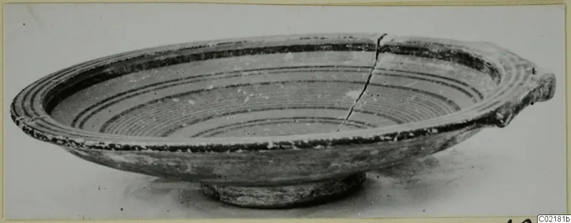 Pottery Black-on-Red II-IV bowl with concentric bands inside and a small projection at one side