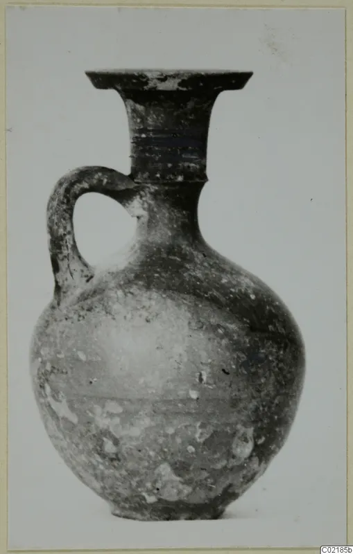Jug with a single loop handle, a flared rim and a rounded body, shown against a plain light background