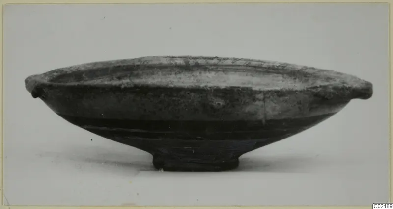 Bichrome-Red bowl with two small side handles and a low ring foot, photographed from the side on a pale surface.