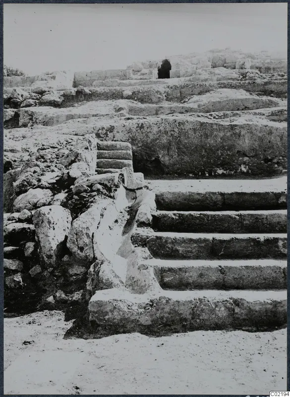 Stone steps and rubble walls at Vouni Palace, with a dark opening in a wall behind