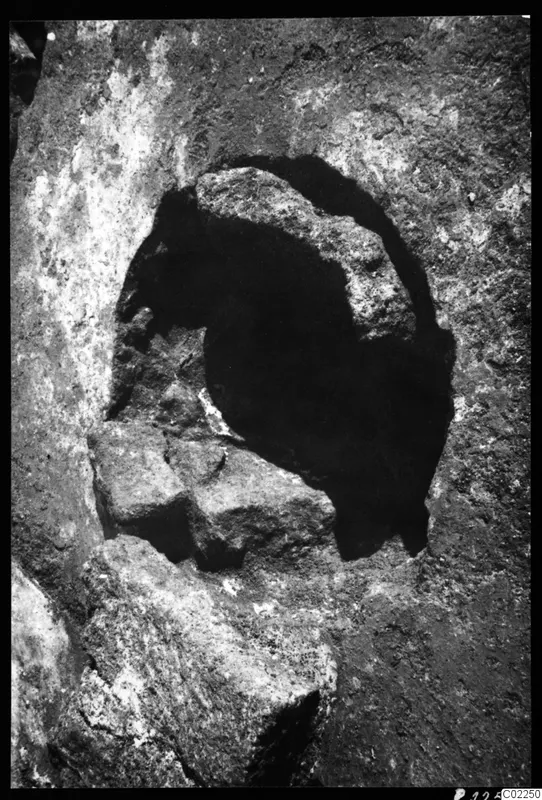 Rock-cut press in Room XXI at Kition: a rounded hollow in rough rock with stone blocks at its edge