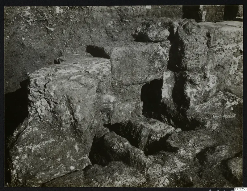 Excavated stone blocks and wall remains at Kition, room 10, with dark openings between them
