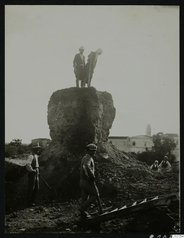 Mound called Bamboula being torn down at Kition, with two men on top and workers standing below