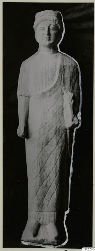 Limestone standing statue from Vouni, wearing a long draped garment with diagonal folds.
