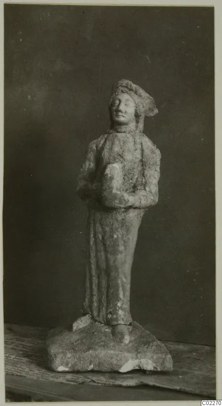 Small limestone figurine of a standing figure in a cap and long garment, from Vouni