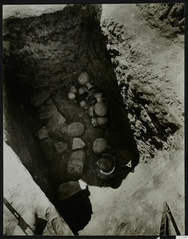 Finds in situ in Tomb 19 at Amathus: jugs, juglets and bowls lying among stones at the bottom of a cut.