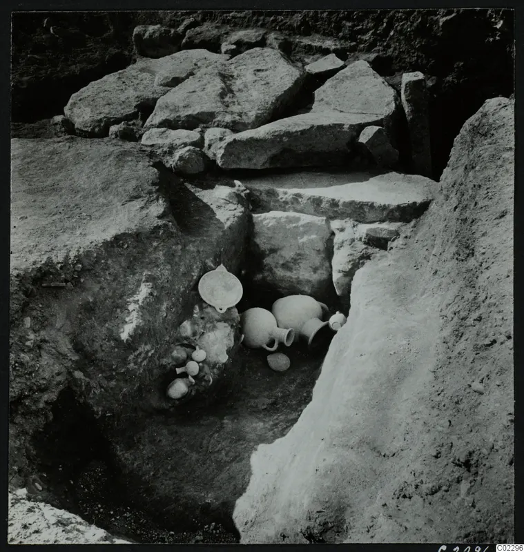 Excavation at Amathus with pottery vessels lying among large stone blocks in a trench