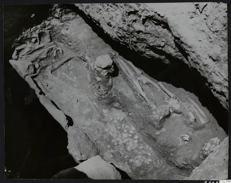 Excavation at Amathus showing a skeleton and scattered stones on a sloping rock-cut floor