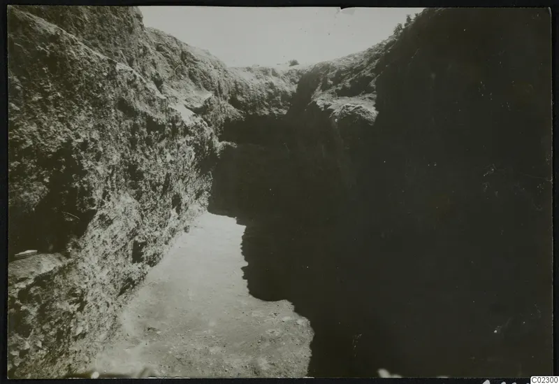 Excavation cutting at Amathus with steep stony walls and a sandy floor running away from the viewer.