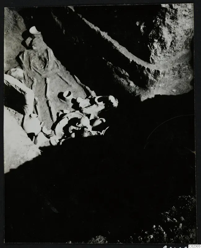 Skeleton and pottery vessels in a rock-cut tomb at Amathus during excavation