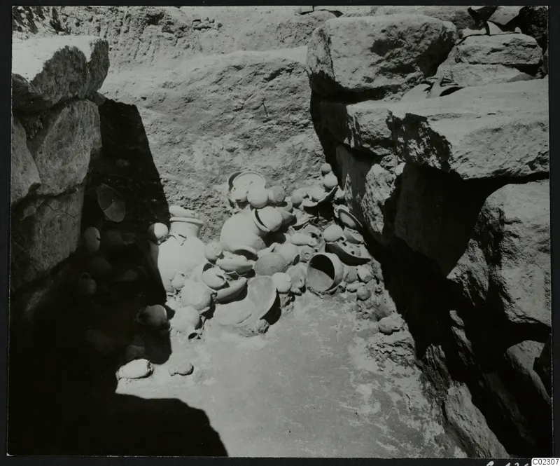 Excavation at Amathus with a cluster of pottery vessels lying on the floor between large stone blocks