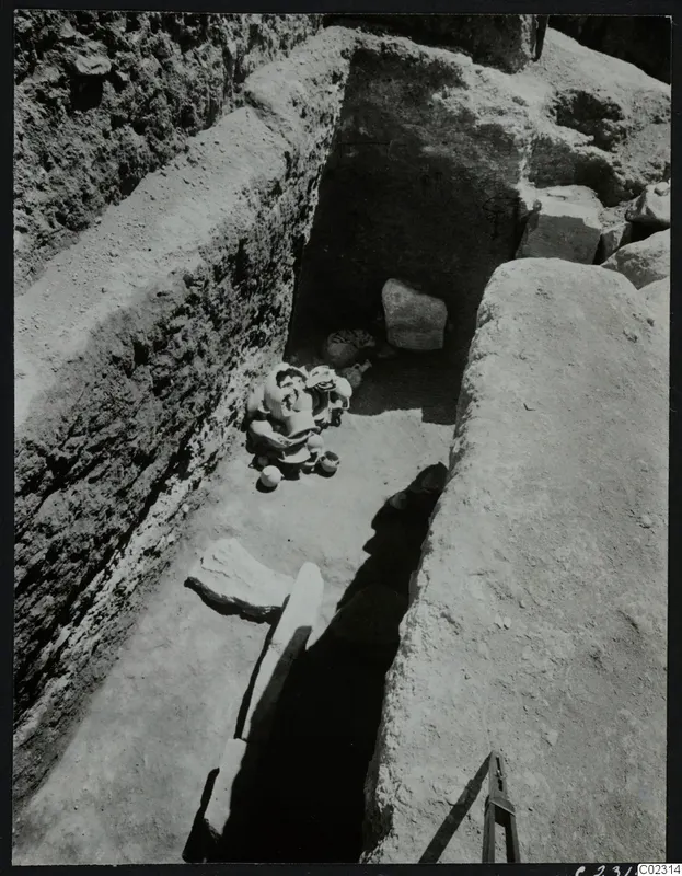 Excavation at Amathus: a cut trench with a cluster of pottery vessels and large stone blocks on its floor