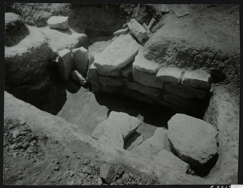 Excavation at Amathus showing a stone wall and scattered stone blocks in an excavated trench
