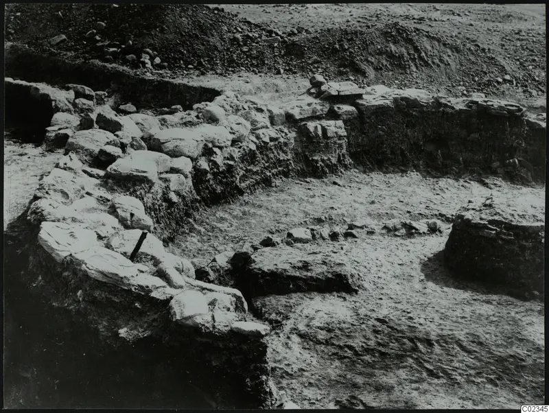 Excavated stone walls at Kythrea, with a spoil heap of earth and stones behind them