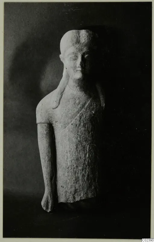 Limestone statue of a standing figure with a plait over one shoulder, shown against a dark background