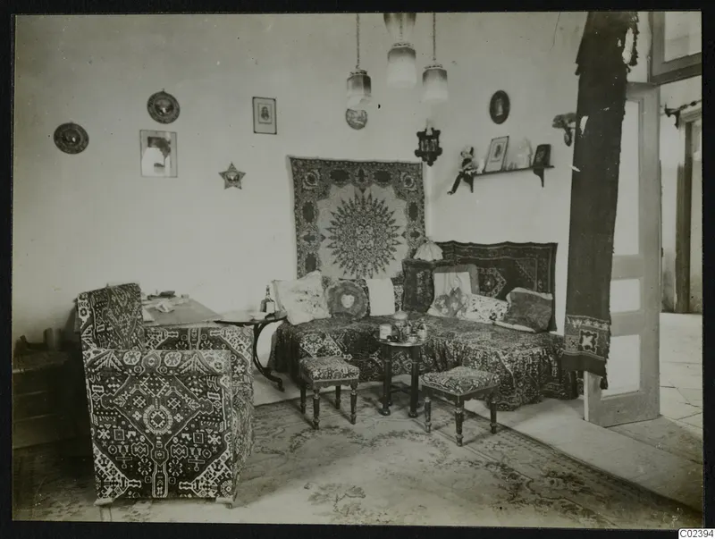 Salon interior at Kition with a sofa, upholstered armchair, low stools and hanging lamps