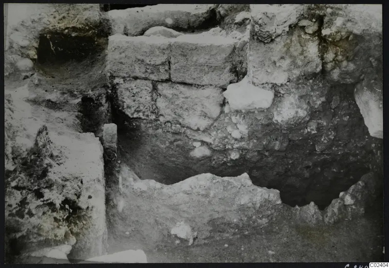Excavated ancient walls at Kition, built of rough stone blocks in a trench.