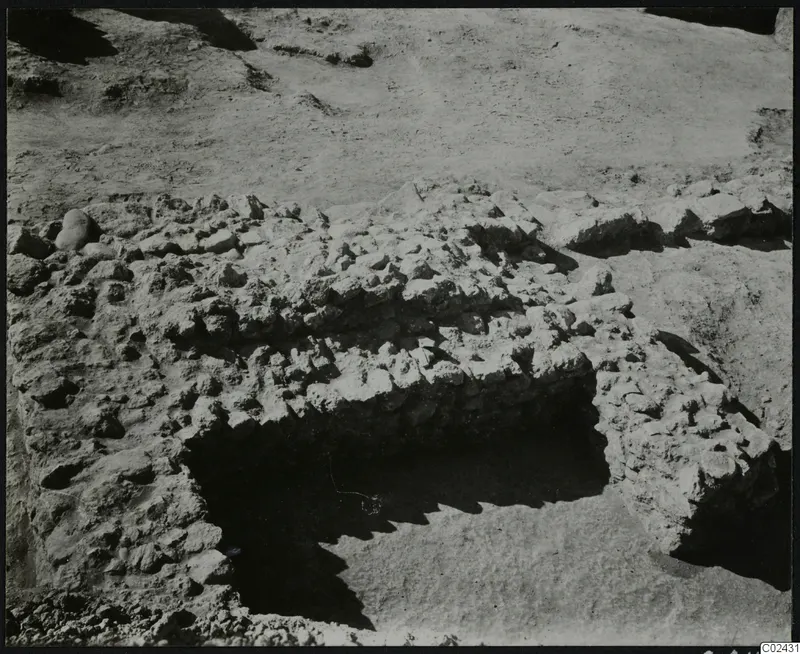 Excavated stone wall and loose stones at Ayia Irini, seen from above during excavation.