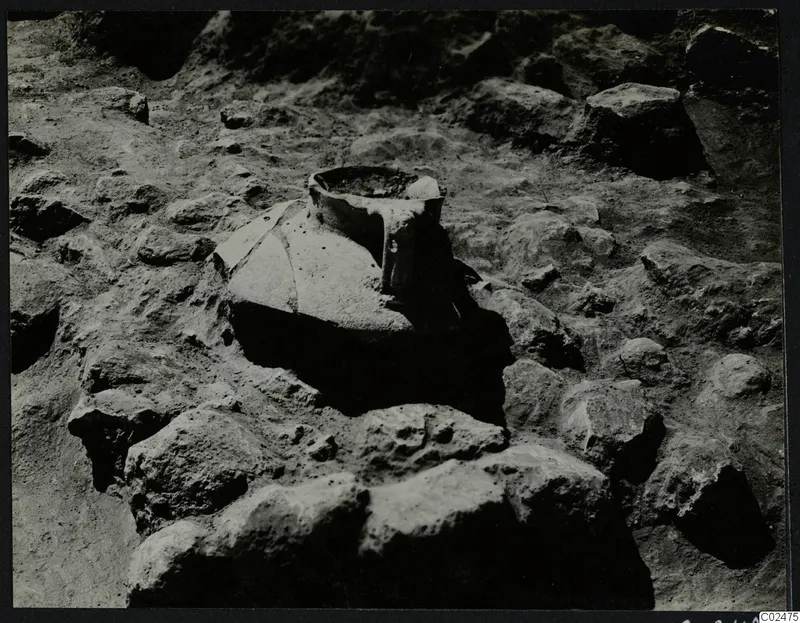 In situ vessel with a wide mouth, set among stones during excavation at Ayia Irini