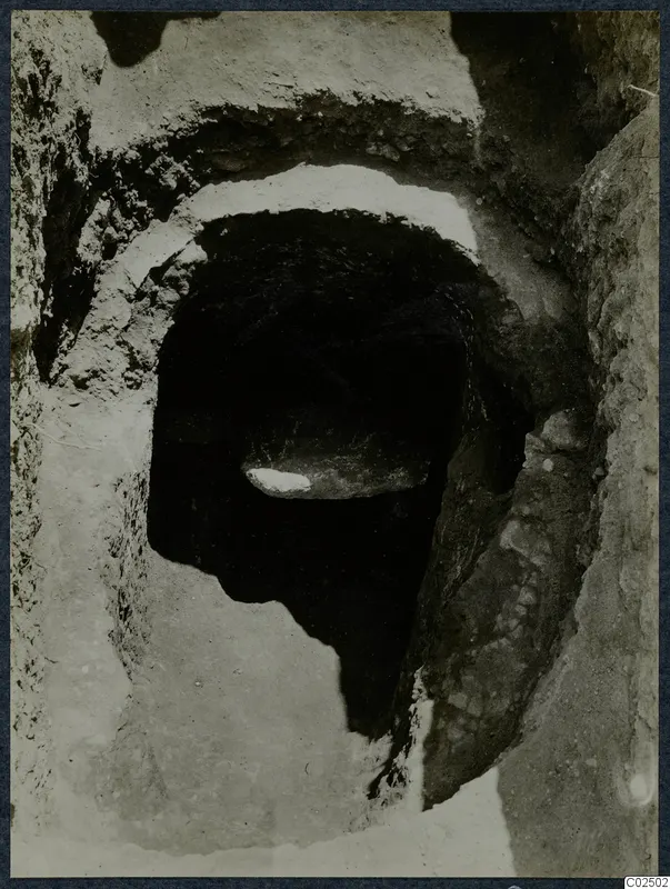Tomb 3 at Enkomi: opening of a rock-cut tomb chamber seen from its dromos, with stones inside