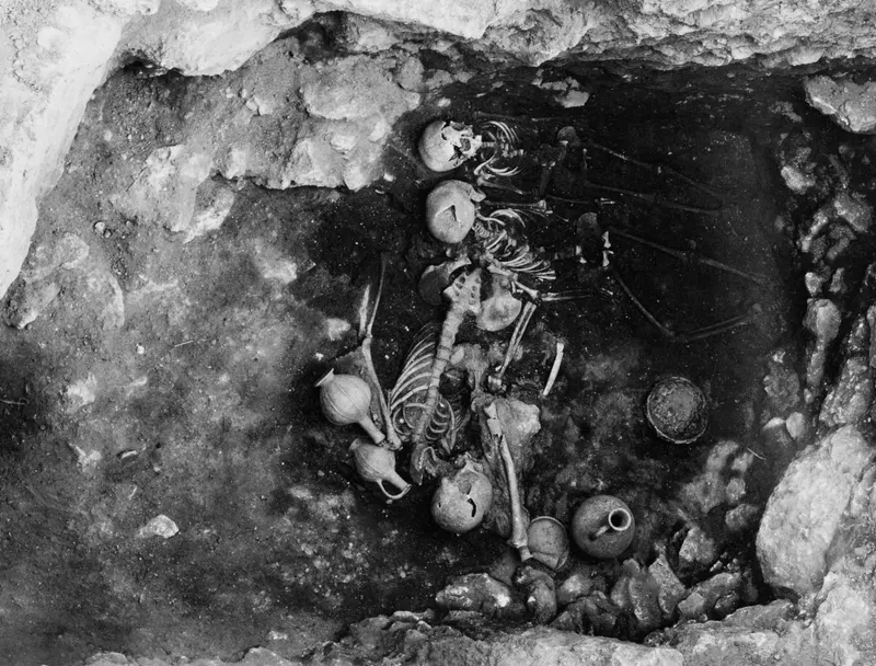 Interior of Tomb 14 at Enkomi with several skeletons and pottery vessels lying in the chamber