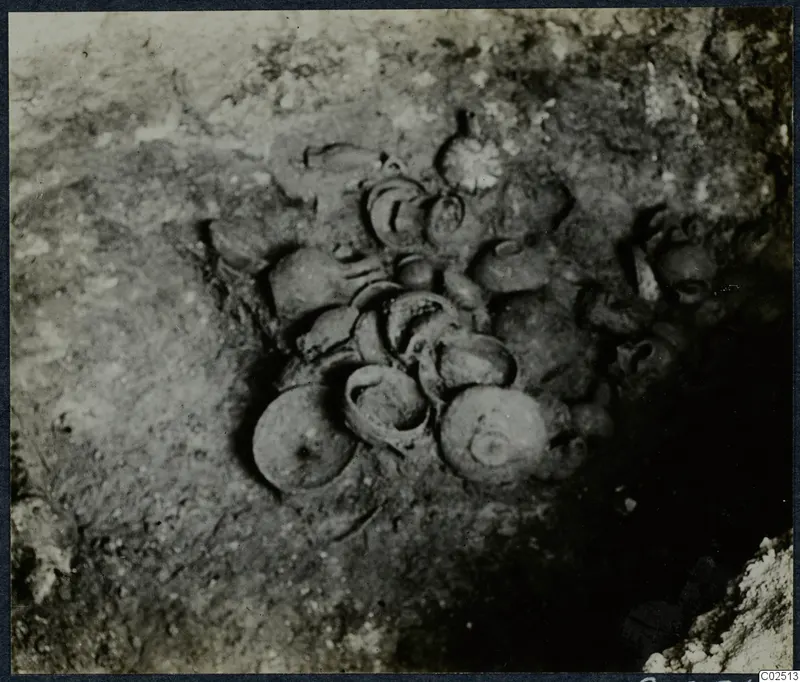 Tomb 13 at Enkomi during excavation, with a cluster of vessels lying in the soil of the tomb chamber
