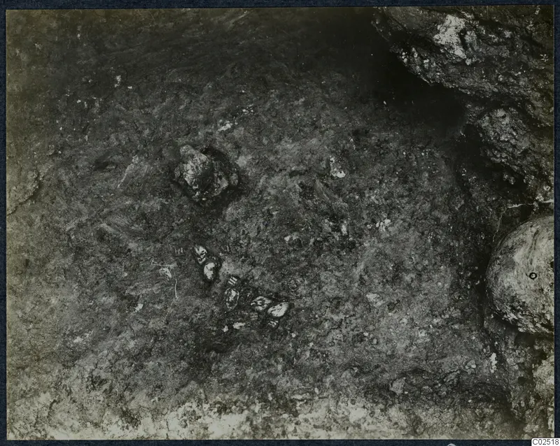 Tomb chamber floor at Enkomi during excavation, with small finds lying in the soil
