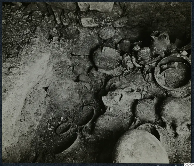 Tomb 13 at Enkomi during excavation, with pottery vessels and bones lying in the tomb chamber