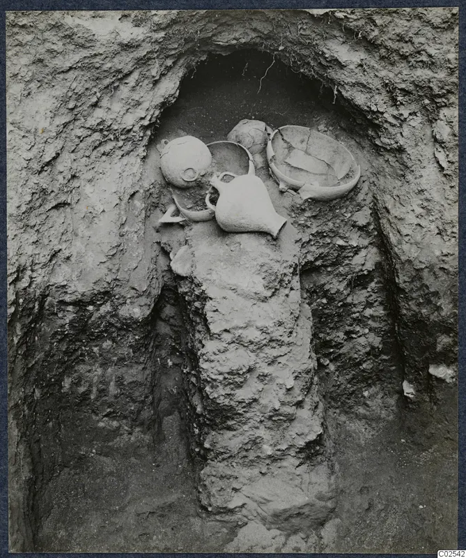 Pottery vessels lying in situ in an excavated niche at Ayios Iakovos