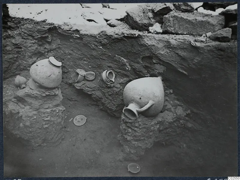 Pottery jugs and bowls in situ during excavation at Marion, Tomb 83