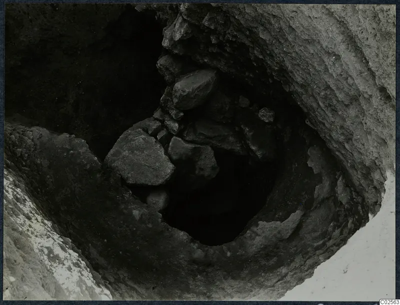 Tomb 18 at Enkomi: a dark opening with fallen stones, seen from above during excavation