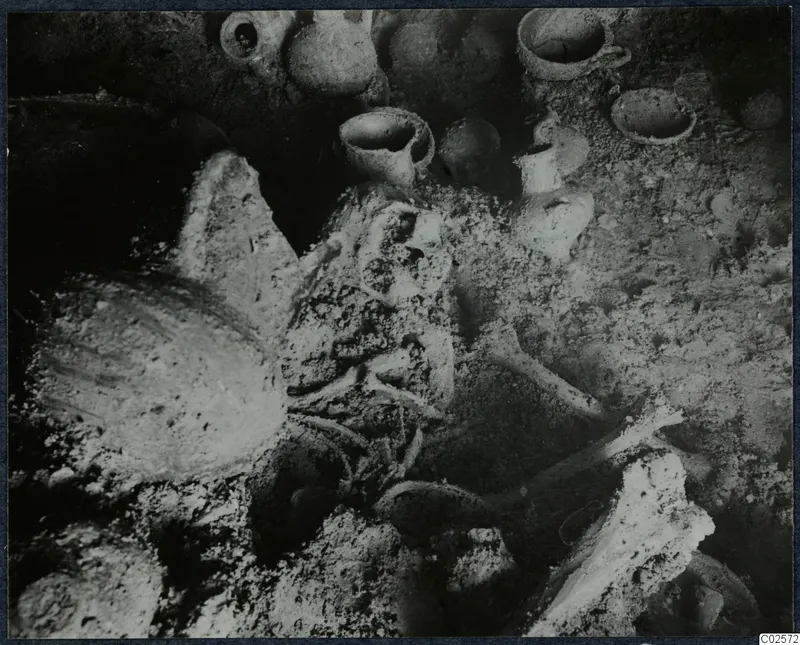 Tomb chamber at Enkomi with a skeleton and pottery vessels during excavation