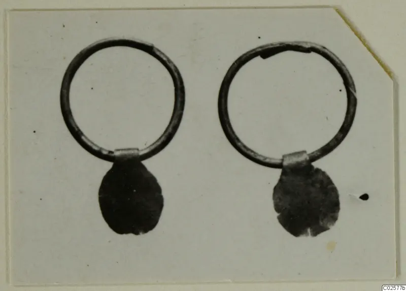 Two ring earrings, each with a flattened pendant drop, photographed side by side.
