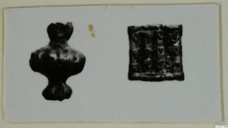 Two small dark objects on a pale card: a figure-like piece on the left and a square piece with a patterned surface on the right.