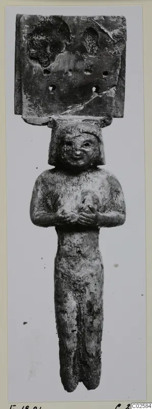 Bone figure from Enkomi: a small standing figure with arms folded across the chest and a plaque with holes above the head