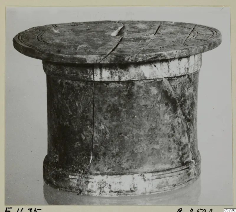 Cylindrical lidded object with a flat lid, cracked, with incised concentric rings on the top, from Enkomi