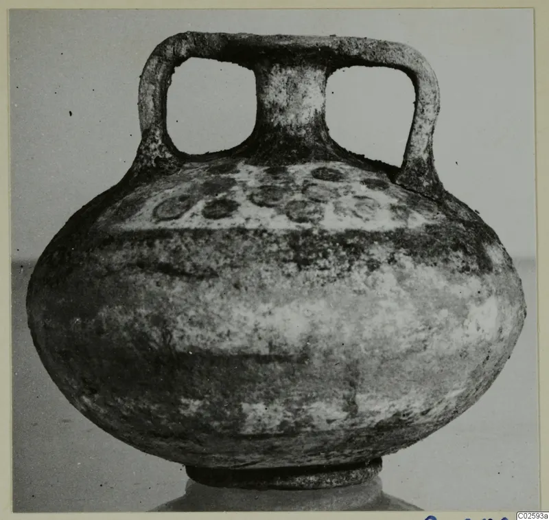 Round, squat vessel with two strap handles and a short neck, photographed from the front against a plain backdrop.